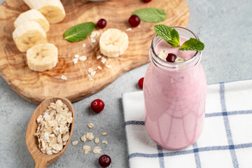 Homemade yogurt smoothie with banana, cranberry and oatmeal