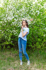 A spring walk. A girl walks through a blooming spring apple garden