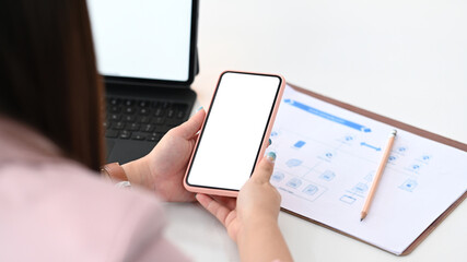 Businesswoman using smart phone for synchronizing data with computer tablet.