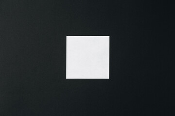 Blank square sheet of white paper on a black background