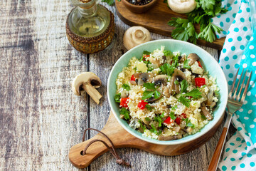 Diet food vegan concept. Vegan salad with couscous and champignons on a wooden table. Copy space.