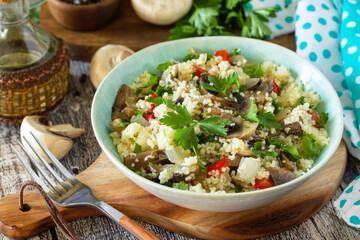 Diet food vegan concept. Vegan salad with couscous and champignons on a wooden table.