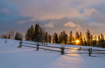 A fiery, dramatic sunrise in a winter mountain scenery