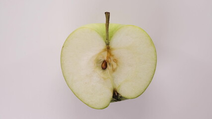 beautiful freshly cut green apple is spinning on table. Top down view of isolated fruit, freshly harvested from tree and ready to eat.