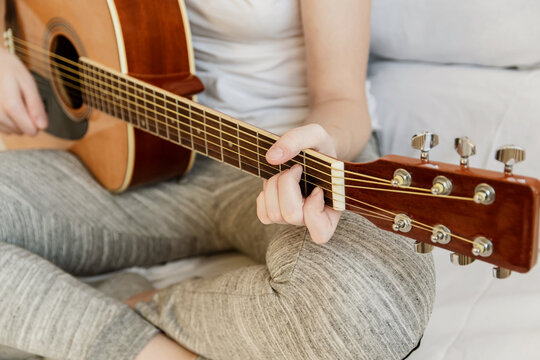 Close-up of women's hands on the guitar. A girl plays the guitar.
