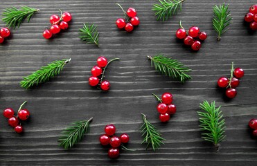 Christmas background with red berries and spruce branches on a wooden background