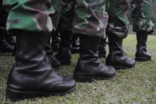 close up photo of a soldier's boot standing on the grass
