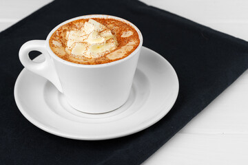 Cup of coffee with whipped cream on white table