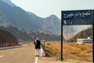 a Bedouin man stands on the road waiting for transport, Wady Megarah, Sinai, Egypt