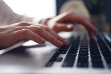 Female young hands with manicure typing text on laptop. Working with laptop at home. Close-up.