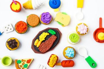 View of miniature toy kitchenware and foods on white background. Image with selective focus and flat lay.