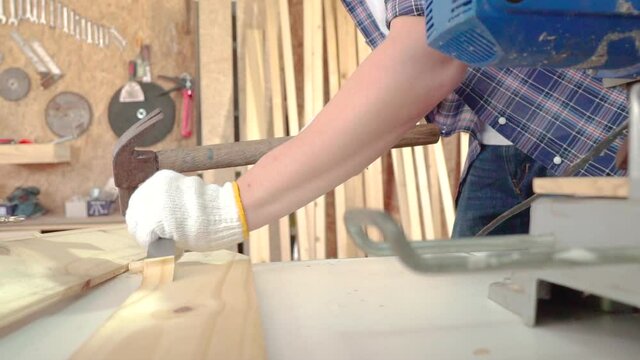 The carpenter is using a hammer to chisel To trim wood