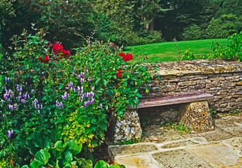 Simple wooden seating against stone wall in a garden