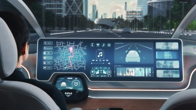 Futuristic Concept: Stylish Businessman Setting Location on an Interactive Navigation App on an Augmented Reality Dashboard while Sitting in an Autonomous Self-Driving Zero-Emissions Electric Car. 