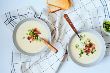 potato cream soup with bacon and green onion served in bowl on white background. Delicious food for...