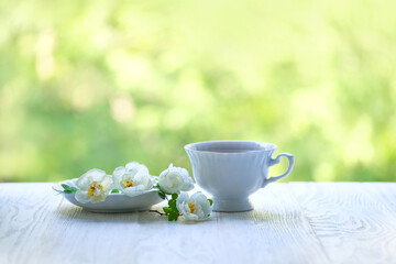 Cup of tea and white flowers on white table. beautiful spring romantic composition. atmosphere Tea party. copy space