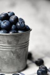 Closeup of Fresh ripe blueberries in a small metal bucket. Side view. Rustic.