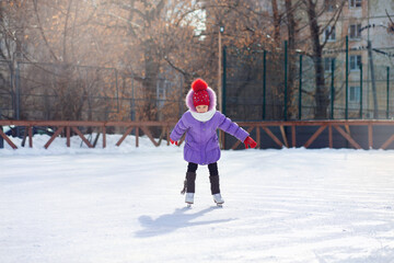 Girl ice skating in winter on an ice rink