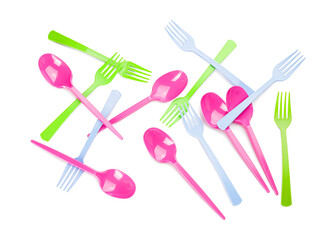 Plastic spoons and forks on white background