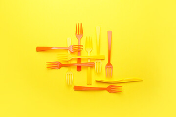 Plastic forks on color background