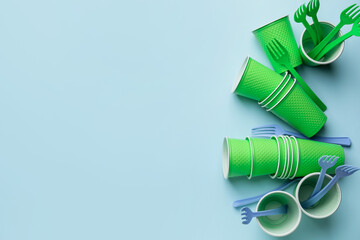 Plastic cups and forks on color background