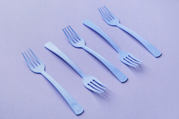 Plastic forks on color background