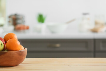 Bowl with fruits on table in modern kitchen