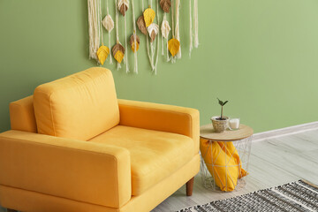 Armchair and table near color wall in room