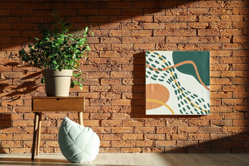 Table with houseplant near brick wall