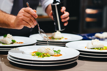 two hands preparing fish on plate