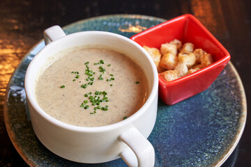 Creamy onion soup with green. Health food at cafe. Classic cuisine. Cooking bowl with bread croutons. Yam dish. Hot vegetable plate