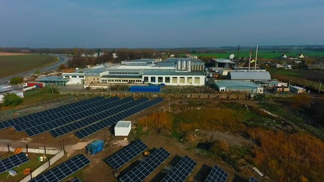 Blue solar panels and manufactoring factory with blue sky above. Background of photovoltaic modules for renewable energy. Video from drone.