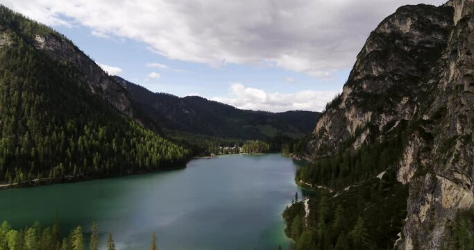 Beautiful Aerial Landscape in the Alps, Lake Braies Aerial view over Treetops in the Dolomites surrounded by steep Mountains. Bird Eye View of Alpine Landscape in 4K. Steep Valley in South Tyrol