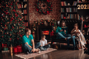 A family with three children decorates a Christmas tree