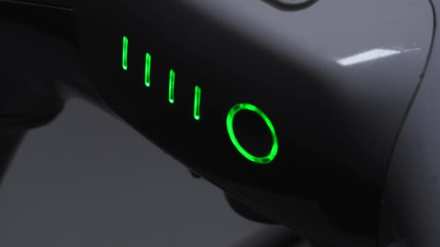Close-up Of The Green Lights Of The White Drone Blink While Charging