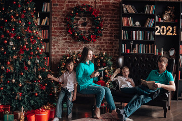 A family with three children decorates a Christmas tree