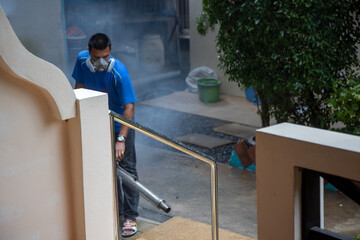 insect treatment. man in a respirator sprays smoke poison
