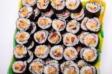 Top view of stack of Japanese sushi maki roll plate. Served in Japanese bar restaurant with chopstick