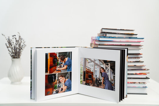 open photobook from photo shoots of woman with a microscope. stack of books