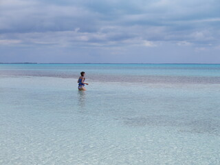 a woman standing in the water on Current Island in the month of February, Bahamas