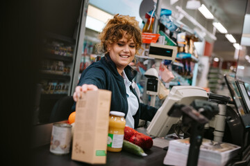 Woman working in modern supermarket - obrazy, fototapety, plakaty