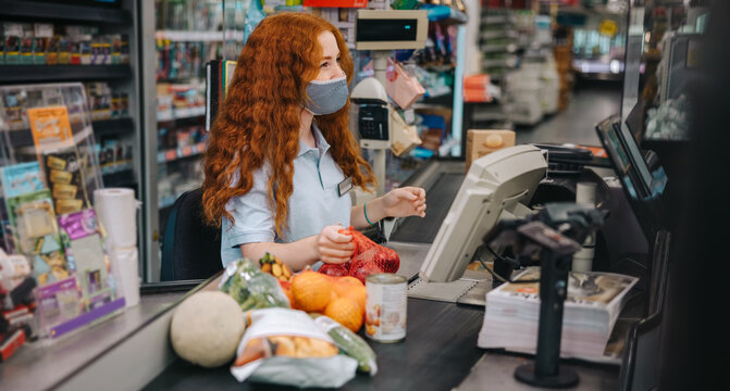 Female cashier working with protective mask