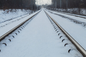 The rails are covered with snow, View along the railway