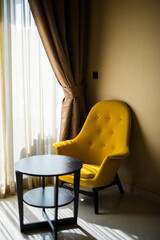 Yellow armchair opposite the window.  modern living room design. 