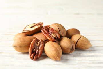 Tasty pecan nuts on white wooden background