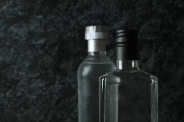 Blank bottles of vodka on black smokey background, space for text