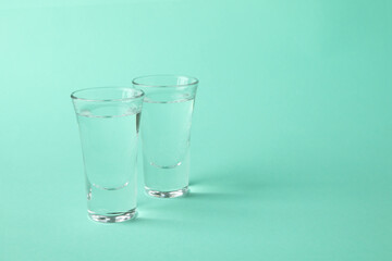 Shots of vodka or tequila on mint background