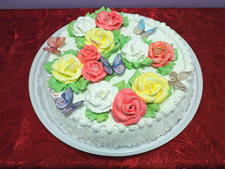 Cake decorated with cream in the form of roses and butterflies. Russian traditional cuisine. Bakery products. Cooking.