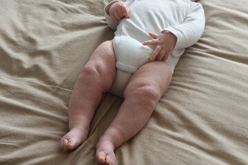 the legs of a baby who is lying on the bed