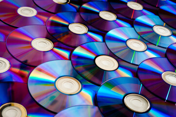 Background CD and DVD discs laid out on a flat surface. Background for saving information. Abstraction.